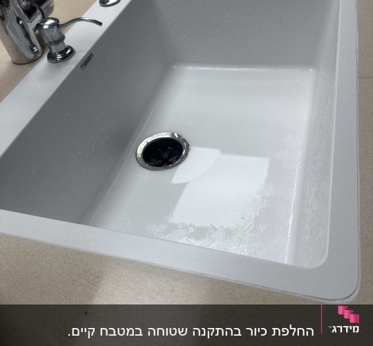 כיור לבן עם ברז על משטח בהיר